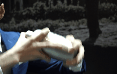 An animated GIF of a bartender's hands rapidly shaking a cocktail shaker with both hands