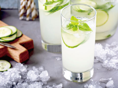 A refreshing cucumber ade garnished with cucumber slices and fresh mint, served over ice in a highball glass