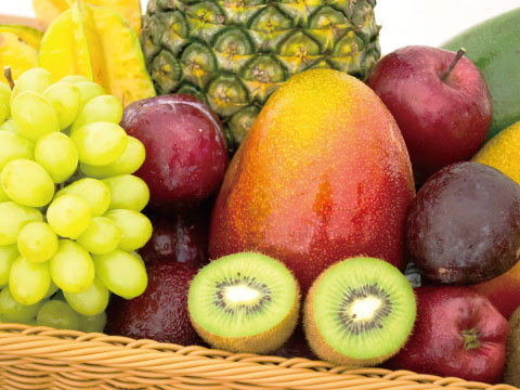 An assortment of fresh fruits including grapes, mango, kiwi, star fruit, and pineapple, representing the sugar-rich ingredients used in single fermentation to produce alcohol