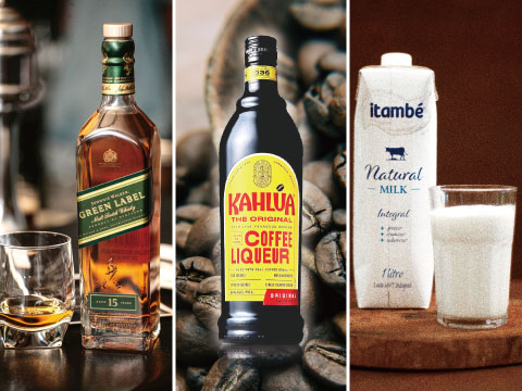 A bottle of Scotch whisky, Kahlúa coffee liqueur, and a carton of milk with a glass, arranged with coffee beans