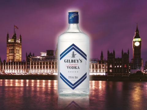 Gilbey's vodka bottle in front of the Houses of Parliament and Big Ben illuminated at night