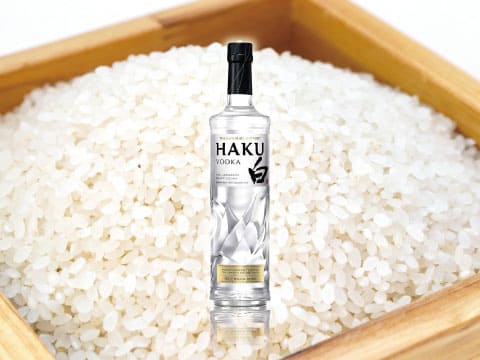 HAKU vodka bottle standing in a wooden box filled with polished Japanese rice