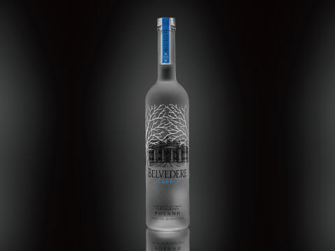 Frosted glass Belvedere vodka bottle featuring an illustration of Belweder Palace against a dark backdrop