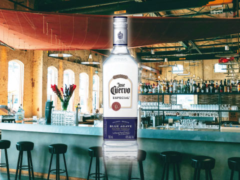 A bottle of Jose Cuervo Especial silver tequila displayed against a warmly lit bar counter