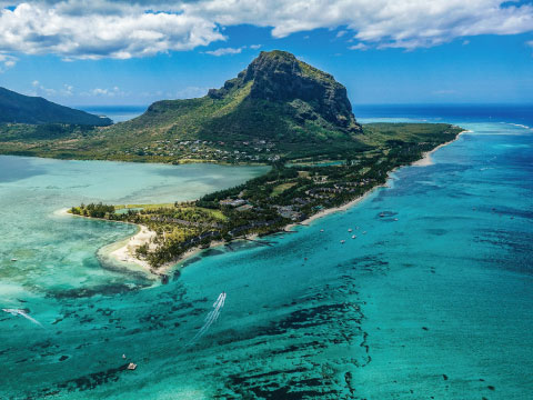 An aerial view of Mauritius's turquoise coastline with Le Morne Brabant mountain rising in the background
