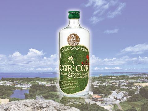 A bottle of Cor Cor Agricole Okinawan rum superimposed over an aerial view of Minamidaitō Island and its coastline