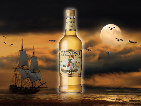 A bottle of Calypso Gold rum against a stormy sky with a pirate ship silhouette and full moon