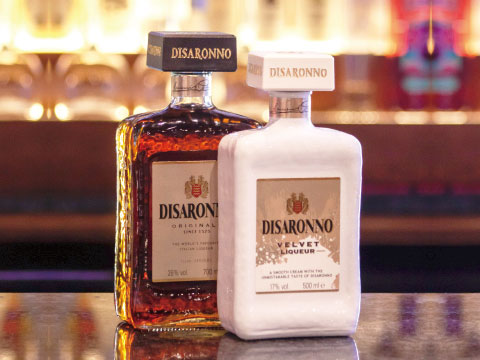 Two Disaronno amaretto bottles, the amber Originale and the white Velvet cream liqueur, standing side by side on a bar counter