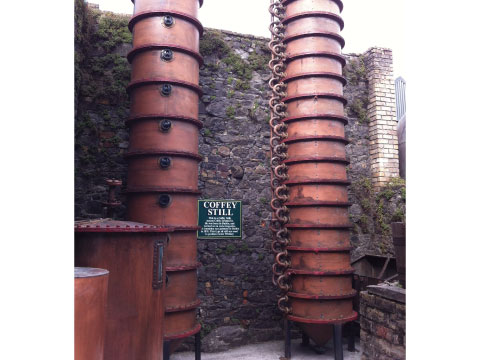 Tall copper Coffey still columns used for continuous distillation at a whisky distillery