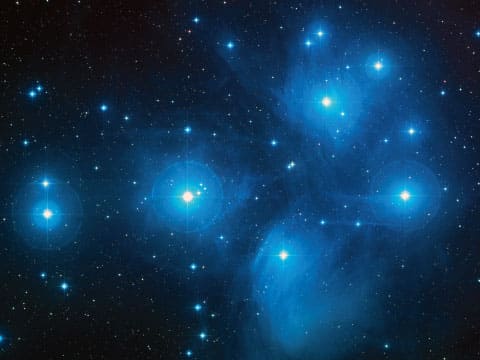 The Pleiades star cluster, also called M45 or Subaru, glowing with bright blue stars and soft nebula against the night sky