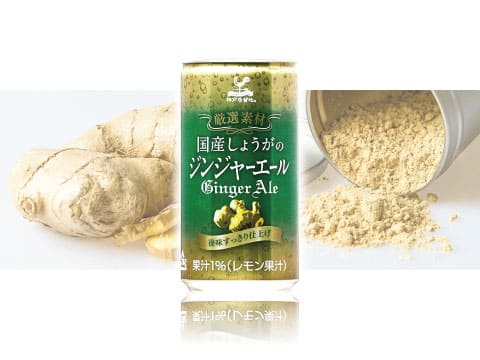 Green can of Kobe Kyoryuchi Ginger Ale, made with Japanese-grown ginger and lemon juice, in front of fresh ginger root and ginger powder