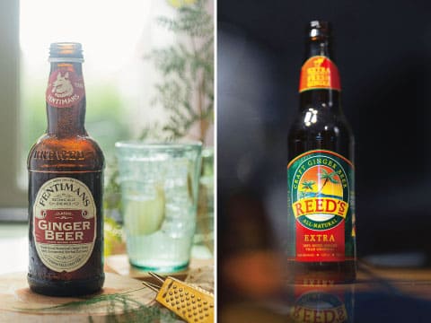 Side-by-side photos of a Fentimans Ginger Beer bottle with a glass of ice and lime, and a Reed’s Extra Ginger Brew bottle on a dark background