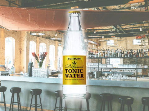 Bottle of Suntory Professional Tonic Water, a classic Japanese tonic for gin, in front of a bright bar counter