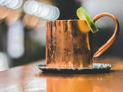 Classic Moscow Mule served in a frosty copper mug with a lime wedge on a bar counter