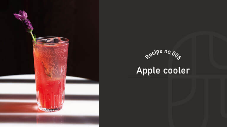 A red Apple Cooler cocktail in a ribbed Collins glass, garnished with a lavender sprig, with "Recipe no.005, Apple Cooler" text overlay