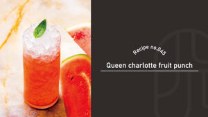 A glass of Queen Charlotte fruit punch topped with crushed ice and mint, garnished with fresh watermelon slices