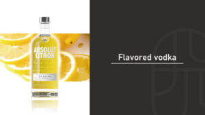 Absolut Citron vodka bottle surrounded by sliced lemons against a dark backdrop