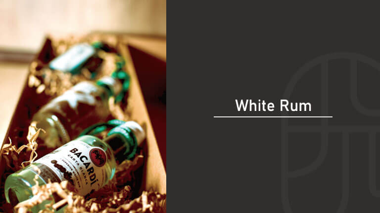 Bottles of white rum nestled in a wooden gift box with excelsior packing material