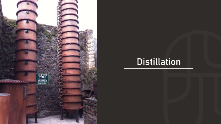 Tall copper Coffey still columns used for continuous distillation at a whisky distillery