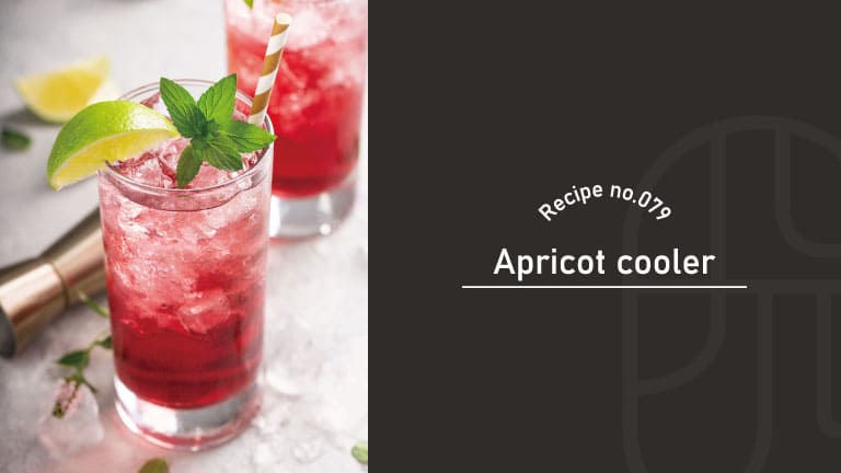 A deep red Apricot Cooler cocktail served over crushed ice in a tall glass, garnished with a lime wedge and fresh mint