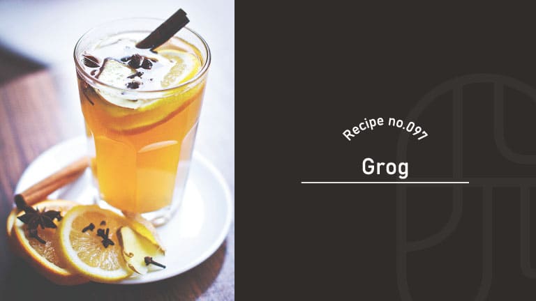 A tall glass of amber Grog cocktail garnished with a lemon wheel, cinnamon stick, and cloves, served on a plate with citrus slices and star anise, beside a "Recipe no.097 Grog" title card