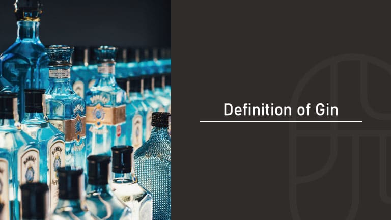 A row of various gin bottles, including Bombay Sapphire, lined up on a bar shelf with blue and clear glass bottles