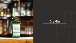 A bottle of Tanqueray London Dry Gin on a wooden bar counter, with rows of blurred liquor bottles glowing in the background