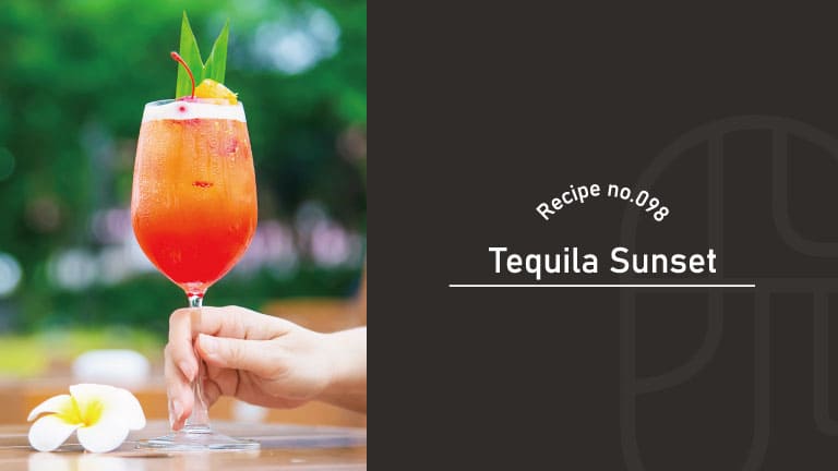 A hand holding a tall glass of orange-red Tequila Sunset cocktail garnished with a cherry, pineapple wedge, and palm leaf, with a plumeria flower on the table and greenery in the background, beside a "Recipe no.098 Tequila Sunset" title card