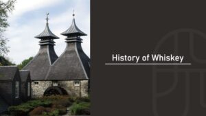 Historic Scotch whisky distillery with twin pagoda roofs and a stone building with a water wheel, with the title “History of Whiskey”