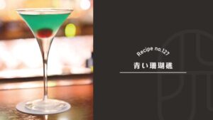 Aoi Sangosho (Blue Coral Reef) cocktail, a classic Japanese gin and mint drink, glowing emerald green in a martini glass with a red cherry sunk at the bottom