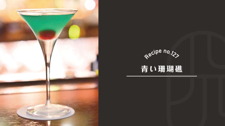 Aoi Sangosho (Blue Coral Reef) cocktail, a classic Japanese gin and mint drink, glowing emerald green in a martini glass with a red cherry sunk at the bottom